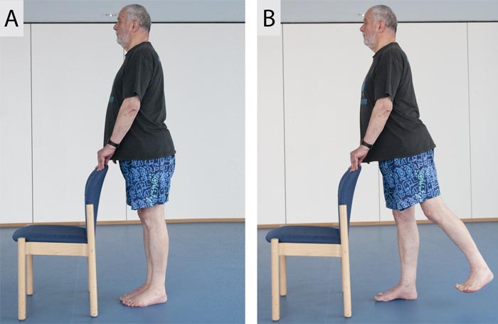 A man stands straght and extends his right leg backwards
